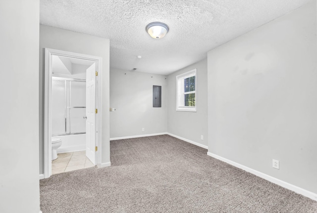 720 Superior Ln, Clarksville, TN 37043 - unfurnished bedroom featuring carpet floors, electric panel, a textured ceiling, connected bathroom, and tile patterned flooring