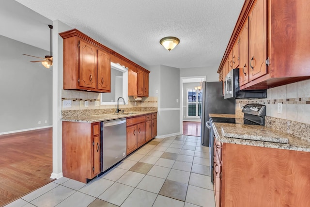 720 Superior Ln, Clarksville, TN 37043 - kitchen featuring stainless steel appliances, decorative backsplash, a ceiling fan, light tile patterned floors, and brown cabinetry