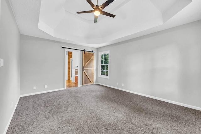 720 Superior Ln, Clarksville, TN 37043 - unfurnished bedroom with a raised ceiling, carpet floors, a barn door, and ceiling fan