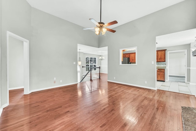 720 Superior Ln, Clarksville, TN 37043 - unfurnished living room with light wood-style floors, a chandelier, high vaulted ceiling, and a ceiling fan