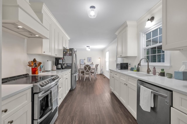 706 Running Deer Dr, Columbia, TN 38401 - kitchen featuring appliances with stainless steel finishes, custom range hood, white cabinetry, dark wood finished floors, and light countertops
