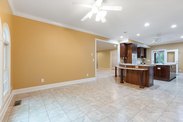 599 Countryside Dr, Loretto, TN 38469 - kitchen featuring ceiling fan, crown molding, light countertops, a breakfast bar, and dark brown cabinetry