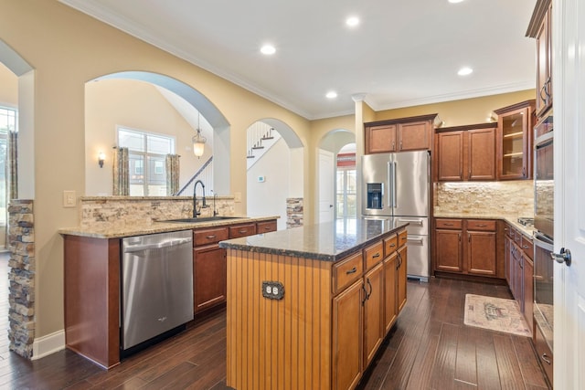 5010 Moretto Ct, Spring Hill, TN 37174 - kitchen featuring stainless steel appliances, dark stone counters, dark wood-style floors, ornamental molding, and recessed lighting