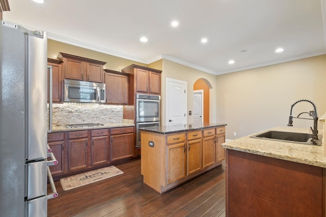 5010 Moretto Ct, Spring Hill, TN 37174 - kitchen featuring stainless steel appliances, a center island, arched walkways, recessed lighting, and dark wood-type flooring