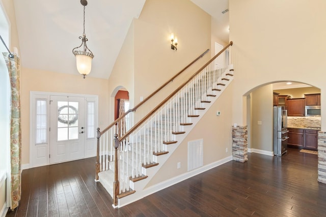 5010 Moretto Ct, Spring Hill, TN 37174 - entryway with high vaulted ceiling, arched walkways, dark wood-style flooring, and stairs