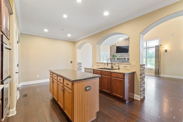 5010 Moretto Ct, Spring Hill, TN 37174 - kitchen with a center island, arched walkways, dark wood finished floors, crown molding, and recessed lighting