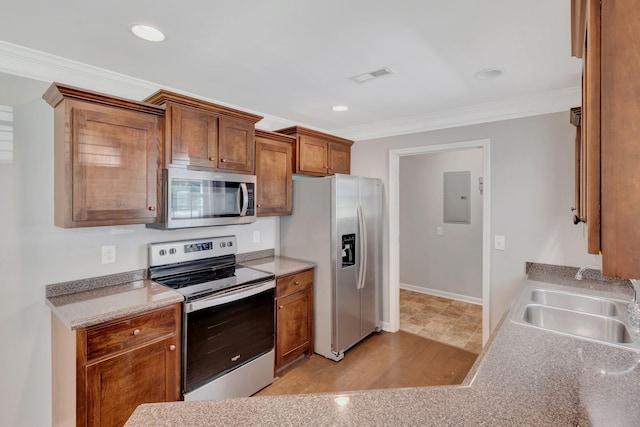 1205 Slaters Creek Rd, Goodlettsville, TN 37072 - kitchen with stainless steel appliances, ornamental molding, electric panel, brown cabinets, and light countertops