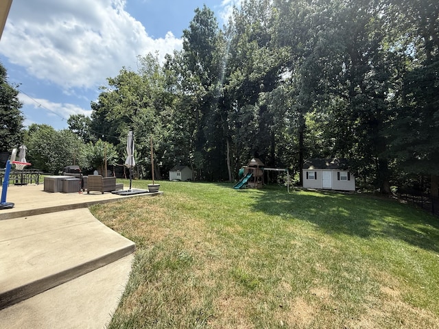 4392 Taylor Hall Ln, Adams, TN 37010 - view of grassy yard featuring a storage unit, a playground, and a patio