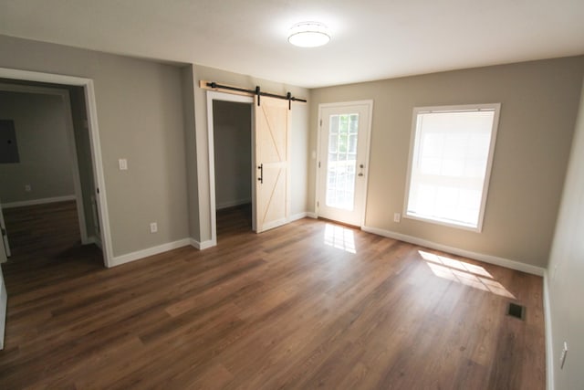 61 Kentucky Dr, Cadiz, KY 42211 - unfurnished bedroom featuring a barn door, dark wood-type flooring, access to outside, electric panel, and a closet