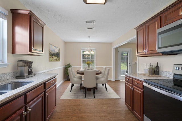 1918 Lawndale Dr, Spring Hill, TN 37174 - kitchen with stainless steel appliances, dark wood finished floors, a chandelier, pendant lighting, and light stone countertops