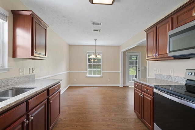 1918 Lawndale Dr, Spring Hill, TN 37174 - kitchen featuring appliances with stainless steel finishes, dark wood-style flooring, a chandelier, light stone countertops, and a textured ceiling