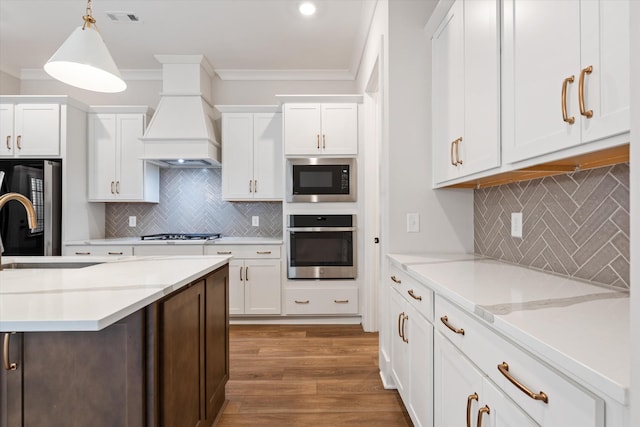 2620 Buckner Ln, Thompsons Station, TN 37179 - kitchen featuring stainless steel oven, black microwave, decorative backsplash, white cabinets, and crown molding