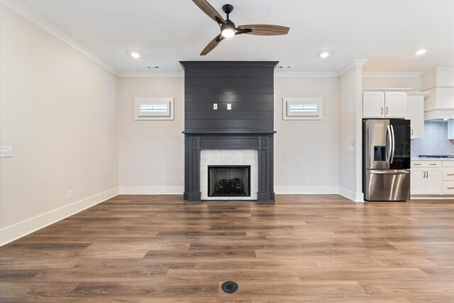 2620 Buckner Ln, Thompsons Station, TN 37179 - unfurnished living room featuring a ceiling fan, crown molding, a fireplace, recessed lighting, and wood finished floors