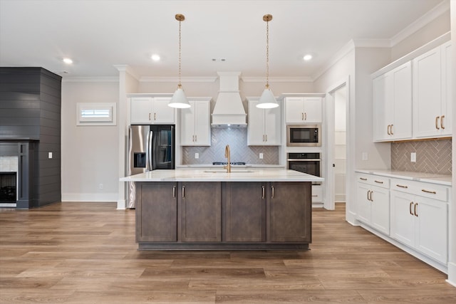 2620 Buckner Ln, Thompsons Station, TN 37179 - kitchen with stainless steel appliances, custom range hood, white cabinets, tasteful backsplash, and a center island with sink