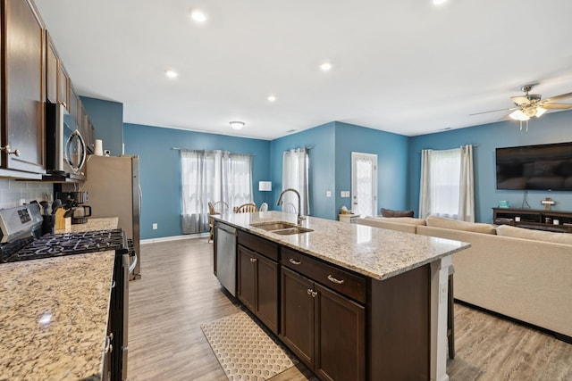 2305 Madeline Ct, Columbia, TN 38401 - kitchen featuring stainless steel appliances, light wood finished floors, dark brown cabinetry, a center island with sink, and recessed lighting