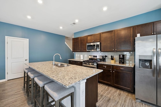 2305 Madeline Ct, Columbia, TN 38401 - kitchen featuring stainless steel appliances, light wood finished floors, a breakfast bar, light stone countertops, and recessed lighting