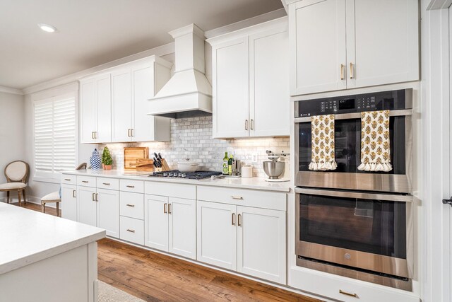 2744 Morrow Ln, Columbia, TN 38401 - kitchen featuring stainless steel appliances, premium range hood, light countertops, white cabinets, and light wood finished floors