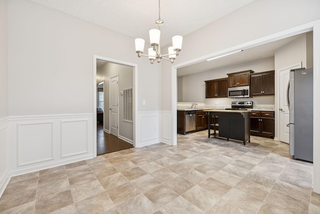 2306 New Holland Cir, Murfreesboro, TN 37128 - kitchen with stainless steel appliances, light countertops, a chandelier, dark brown cabinets, and a kitchen island