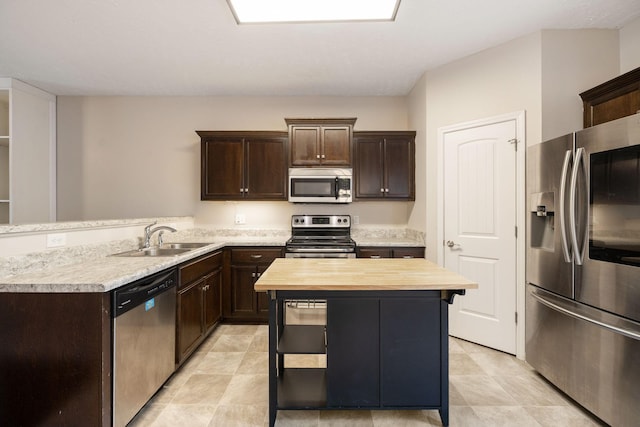 2306 New Holland Cir, Murfreesboro, TN 37128 - kitchen with stainless steel appliances, wood counters, dark brown cabinets, and a kitchen island