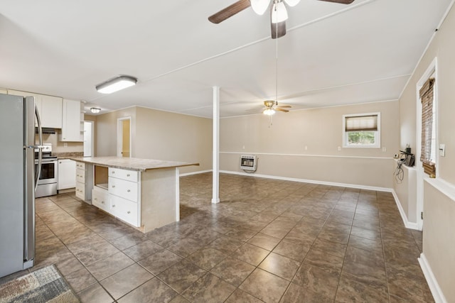 3337 Hartsville Rd, Lafayette, TN 37083 - kitchen with ceiling fan, stainless steel appliances, heating unit, and white cabinetry