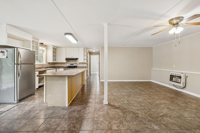 3337 Hartsville Rd, Lafayette, TN 37083 - kitchen with appliances with stainless steel finishes, heating unit, a ceiling fan, under cabinet range hood, and glass insert cabinets