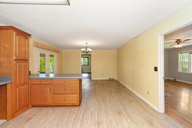 318 David St, Lawrenceburg, TN 38464 - kitchen with light wood-style floors, a peninsula, a chandelier, brown cabinetry, and crown molding