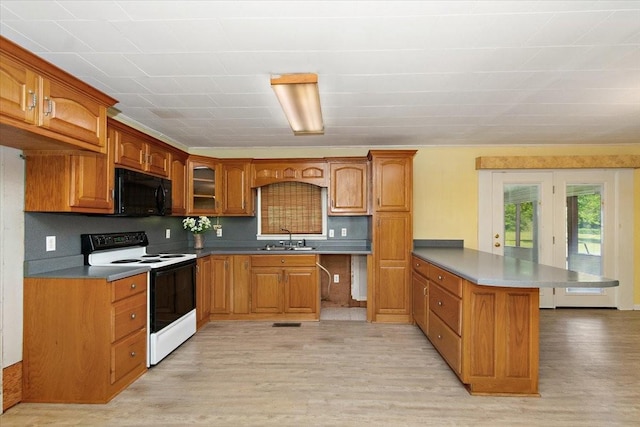 318 David St, Lawrenceburg, TN 38464 - kitchen featuring electric range, black microwave, a peninsula, light wood-type flooring, and brown cabinetry