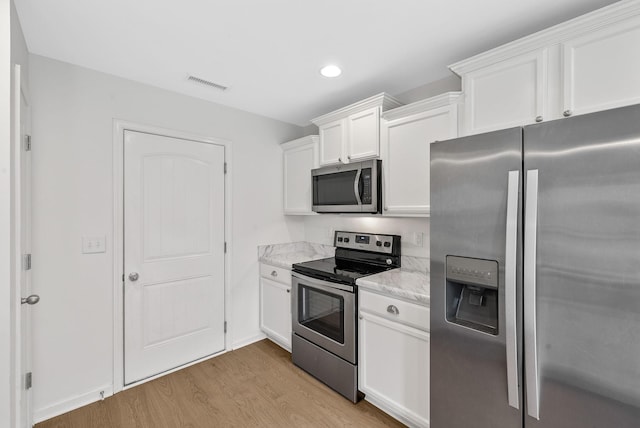 2149 Longhunter Chase Dr, Spring Hill, TN 37174 - kitchen with appliances with stainless steel finishes, light wood-type flooring, white cabinets, recessed lighting, and light stone counters
