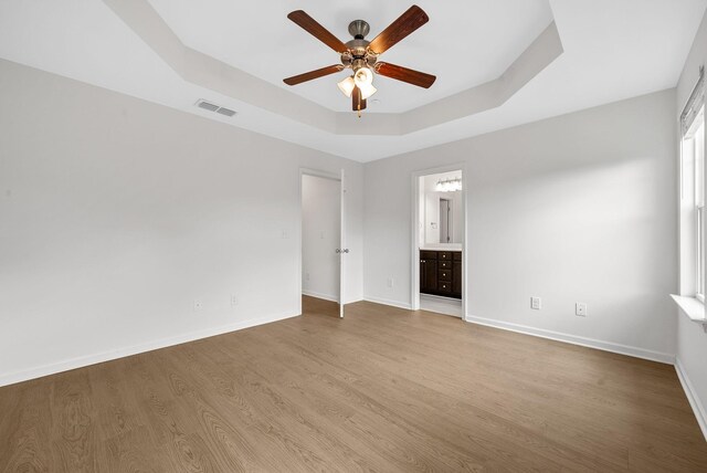 2149 Longhunter Chase Dr, Spring Hill, TN 37174 - unfurnished bedroom featuring a raised ceiling, wood finished floors, ensuite bath, and ceiling fan