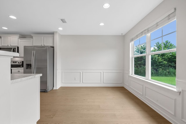2149 Longhunter Chase Dr, Spring Hill, TN 37174 - kitchen featuring appliances with stainless steel finishes, light wood-style floors, wainscoting, white cabinetry, and recessed lighting