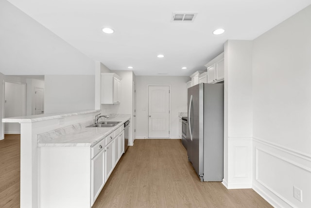 2149 Longhunter Chase Dr, Spring Hill, TN 37174 - kitchen with stainless steel appliances, white cabinetry, light countertops, light wood finished floors, and a peninsula