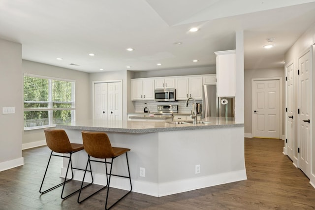 808 Garrett Way Ct, Antioch, TN 37013 - kitchen with stainless steel appliances, white cabinets, tasteful backsplash, dark wood-type flooring, and recessed lighting