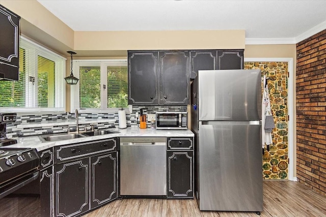 19 Horseshoe Bend Rd, Leoma, TN 38468 - kitchen with appliances with stainless steel finishes, light wood-style floors, light countertops, decorative backsplash, and ornamental molding