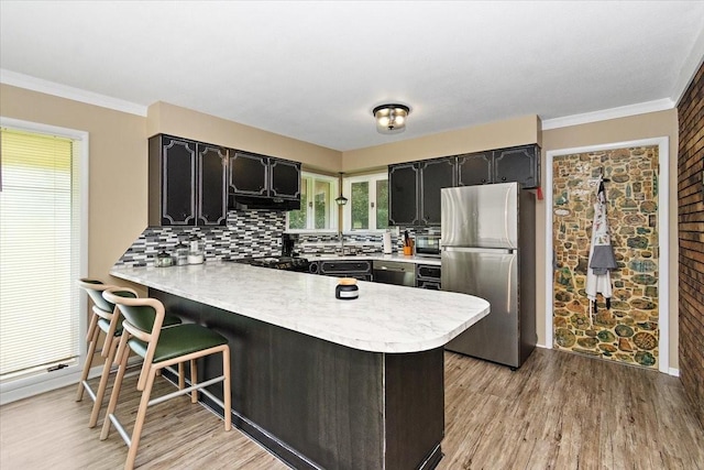 19 Horseshoe Bend Rd, Leoma, TN 38468 - kitchen with freestanding refrigerator, a peninsula, light countertops, dark cabinets, and crown molding