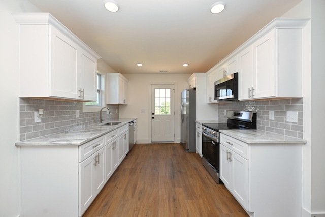 1142 Snow Ave, Madison, TN 37115 - kitchen with appliances with stainless steel finishes, wood finished floors, white cabinetry, recessed lighting, and decorative backsplash