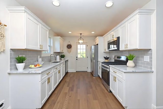 1142 Snow Ave, Madison, TN 37115 - kitchen featuring stainless steel appliances, white cabinetry, recessed lighting, light wood finished floors, and decorative backsplash