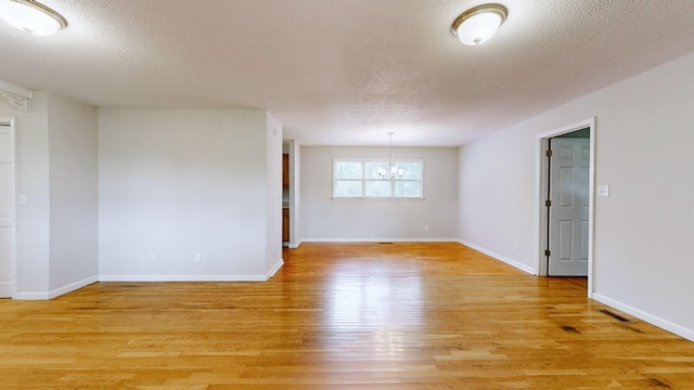 4321 Lynchburg Rd, Winchester, TN 37398 - spare room featuring a chandelier, light wood-style flooring, and a textured ceiling
