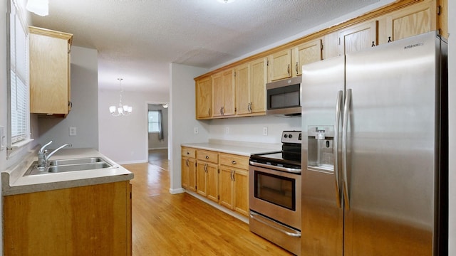 4321 Lynchburg Rd, Winchester, TN 37398 - kitchen with stainless steel appliances, light wood-style floors, a chandelier, a textured ceiling, and light countertops
