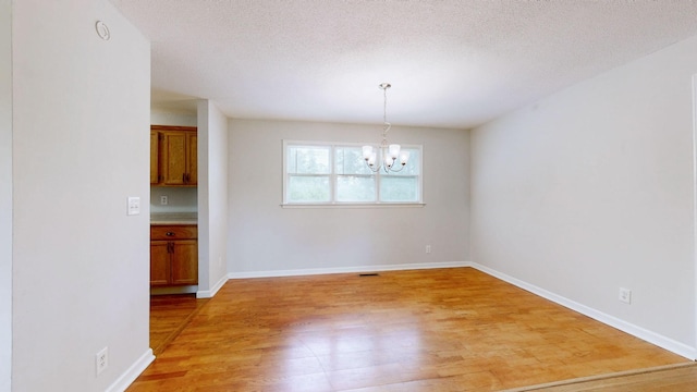4321 Lynchburg Rd, Winchester, TN 37398 - unfurnished dining area featuring light wood-style flooring, a chandelier, and a textured ceiling