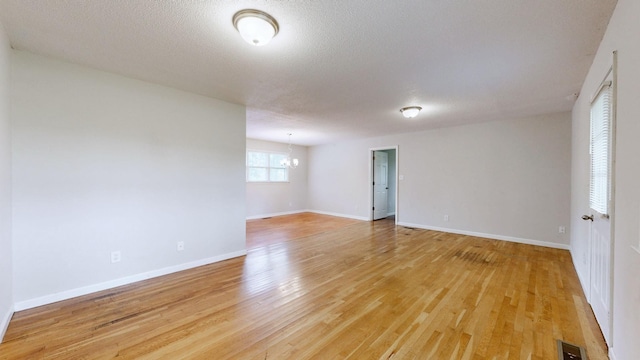 4321 Lynchburg Rd, Winchester, TN 37398 - unfurnished room featuring a chandelier, light wood-style flooring, and a textured ceiling
