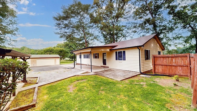 4321 Lynchburg Rd, Winchester, TN 37398 - view of front of house with a garage, an outdoor structure, a metal roof, and a patio area