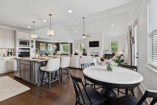 923 Hornsby Dr, Franklin, TN 37064 - dining room with a fireplace, lofted ceiling, a ceiling fan, dark wood finished floors, and recessed lighting