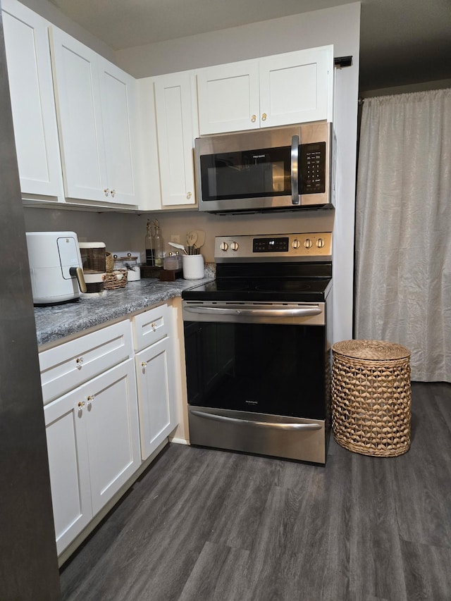 484 Meadowbrook Dr, Mcminnville, TN 37110 - kitchen featuring appliances with stainless steel finishes, dark wood-type flooring, and white cabinets