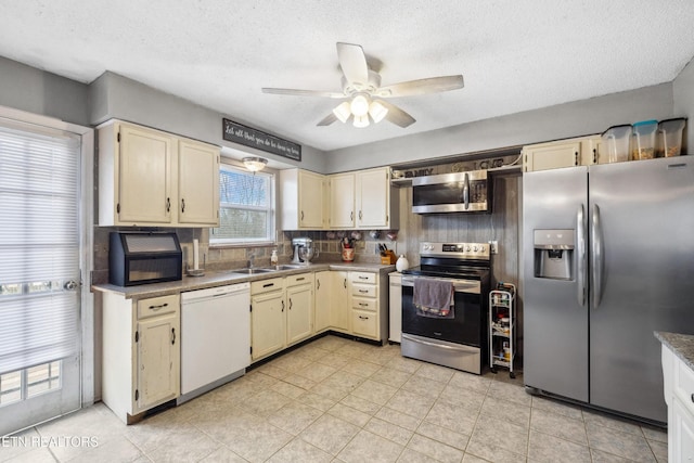 602 Mize Cir, Seymour, TN 37865 - kitchen featuring stainless steel appliances, cream cabinetry, ceiling fan, backsplash, and a textured ceiling