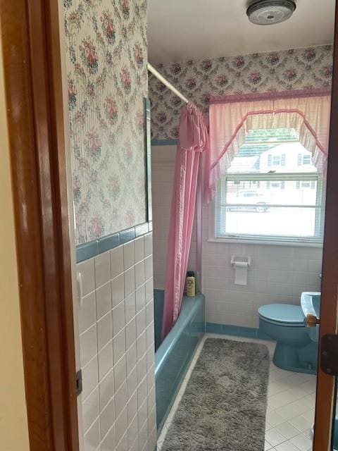 4805 Bowfield Dr, Antioch, TN 37013 - full bathroom featuring wallpapered walls, tile walls, shower / bath combination with curtain, tile patterned floors, and wainscoting