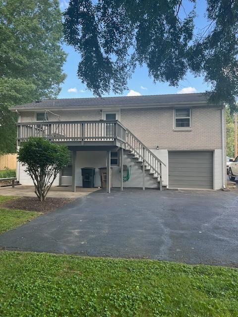 4805 Bowfield Dr, Antioch, TN 37013 - view of front of home featuring an attached garage, asphalt driveway, a deck, stairs, and brick siding