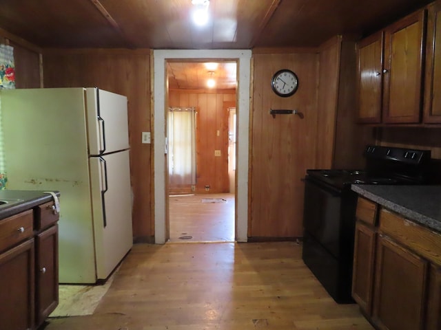 910 17th Ave E, Springfield, TN 37172 - kitchen featuring black electric range, freestanding refrigerator, light wood finished floors, wood walls, and dark countertops