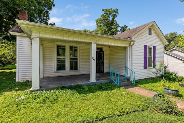 104 3rd Ave, Columbia, TN 38401 - view of front of house featuring a chimney, a front yard, covered porch, and a shingled roof