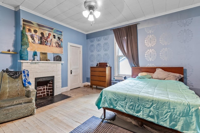 104 3rd Ave, Columbia, TN 38401 - bedroom featuring crown molding, hardwood / wood-style floors, a brick fireplace, a ceiling fan, and wallpapered walls