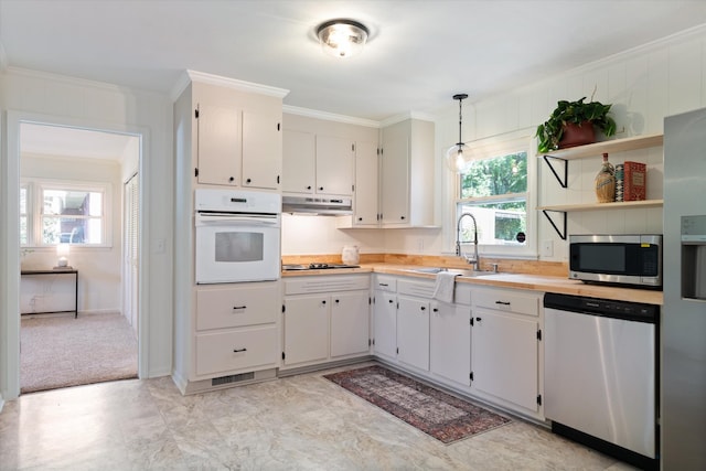 1211 Taylor Pl, Murfreesboro, TN 37129 - kitchen featuring stainless steel appliances, under cabinet range hood, light countertops, crown molding, and open shelves